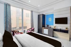 a hotel room with a bed and a flat screen tv at Palette A Lux Corporate Townhouse Near 3 Minutes Kaushambi Metro Station in Ghaziabad
