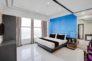 a bedroom with a king sized bed and blue walls at Palette A Lux Corporate Townhouse Near 3 Minutes Kaushambi Metro Station in Ghaziabad