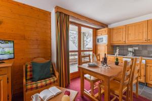 a kitchen and dining room with a table and chairs at travelski home select - Résidence Les Chalets du Galibier 4 - 2 pièces 4 personnes in Valloire