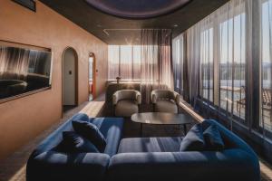 a living room with a blue couch and a table at THE TSUBAKIMORI Hotel & Residence in Chiba