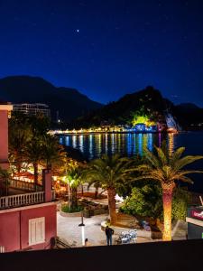 a view of the water at night with palm trees at Apartments MUN Petrovac in Petrovac na Moru