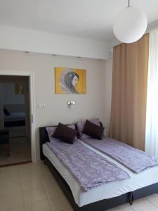 a bedroom with a large bed with purple sheets at Adam Apartman in Hajdúszoboszló