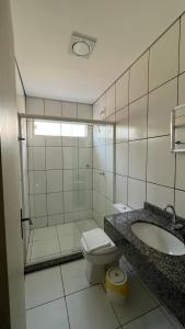 a bathroom with a toilet and a sink and a shower at Apart Hotel Eucalyptus in Telêmaco Borba