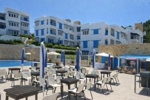 a group of tables and chairs next to a pool at Panoramic View, Cozy apartment M'diq in M'diq
