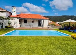 a villa with a swimming pool in front of a house at Casa do Cato in Viana do Castelo