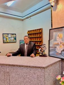 a man in a suit sitting at a counter at Kelany Palace Hotel Aswan in Aswan