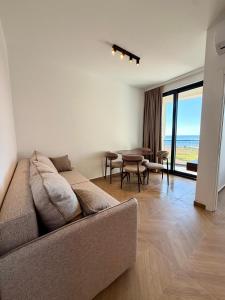 a living room with a couch and a table with chairs at Maresa 1 in Čanj +4 photos