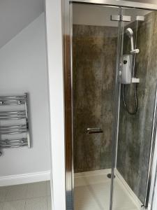 a shower with a glass door in a bathroom at The loft in Tingewick +3 photos