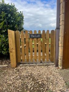 a wooden fence with a sign that reads the loot at The loft in Tingewick