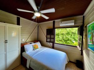 a bedroom with a white bed and a ceiling fan at Annes Retreat in Castries