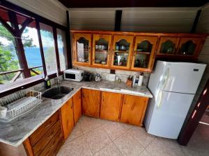 a kitchen with wooden cabinets and a white refrigerator at Annes Retreat in Castries