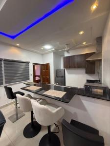 a kitchen with a counter and some chairs in it at Chic Shop House in Abomey-Calavi +44 photos