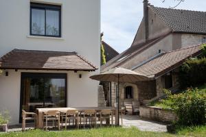 a patio with a table and an umbrella at Maison chic avec Psicine - Talant proche Prenois in Talant