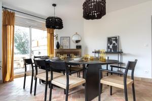 a dining room with a black table and chairs at Maison chic avec Psicine - Talant proche Prenois in Talant