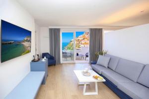 a living room with a couch and a view of the ocean at Hotel & SPA Riviera Castelsardo in Castelsardo