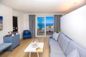 a living room with a blue couch and a table at Hotel & SPA Riviera Castelsardo in Castelsardo