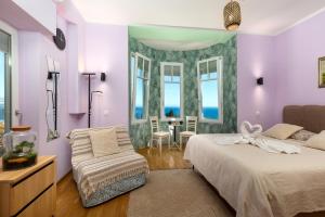 a bedroom with purple walls and a bed and a chair at Blue Horizon Studio Opatija in Opatija