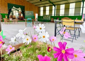 a group of flowers in a room with tables and chairs at La roulotte CIRCUS des Grillots in Beaulon