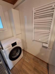 a washer and dryer in a small room with a window at Chalet climatisé 6 personnes in Agde