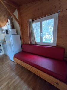 a red bench in a room with a window at Chalet climatisé 6 personnes in Agde