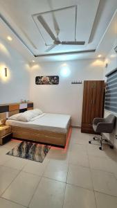 a bedroom with a bed and a desk and a chair at Chic Shop House in Abomey-Calavi