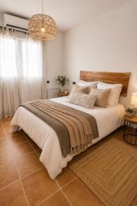 a bedroom with a large bed and a chandelier at Villa Oasys in Almería +25 photos