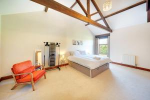 a large bedroom with a bed and a chair at Converted Barn - Super King beds, Parking, WiFi in Hockwold cum Wilton