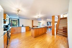 a large kitchen with wooden floors and a staircase at Converted Barn - Super King beds, Parking, WiFi in Hockwold cum Wilton