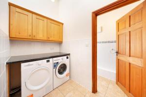 a laundry room with a washing machine in it at Converted Barn - Super King beds, Parking, WiFi in Hockwold cum Wilton