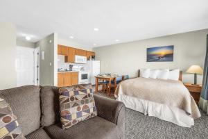 a bedroom with a bed and a couch and a kitchen at Ocean view studio no stairs-Full Kitchen Patio in Lincoln City