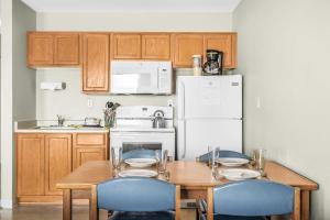 a kitchen with a table with chairs and a refrigerator at Ocean view studio no stairs-Full Kitchen Patio in Lincoln City