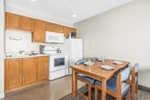 a kitchen with a table and a white refrigerator at Ocean view studio no stairs-Full Kitchen Patio in Lincoln City