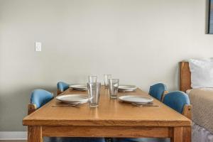 a wooden table with plates and glasses on it at Ocean view studio no stairs-Full Kitchen Patio in Lincoln City +24 photos