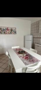 a white table in a kitchen with two white chairs at Sogno vesuviano 4 in Torre del Greco