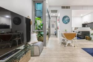 a living room and kitchen with a table and chairs at The Port Melbourne Experience in Melbourne