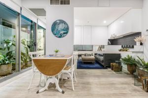 a kitchen and living room with a table and chairs at The Port Melbourne Experience in Melbourne