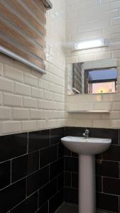 a bathroom with a white sink and a mirror at Chic Shop House in Abomey-Calavi