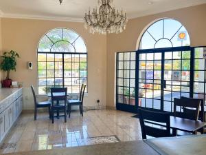 a dining room with windows and a table and chairs at Castaic Inn Six Flags Valencia in Castaic