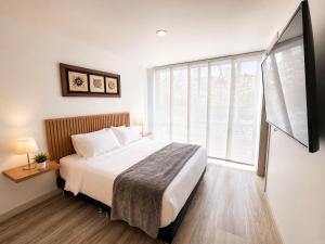 a bedroom with a bed and a large window at Comodo Apto Diagonal MALL PLAZA in Manizales