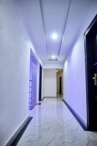 an empty hallway with a door and a tile floor at BROOKLYN HoTEL in Benin City