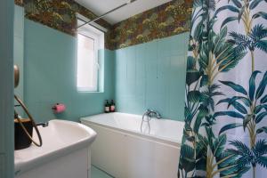 a bathroom with a white tub and blue tiles at Old Town Smârdan Studios - Central Lively Area in Bucharest +47 photos
