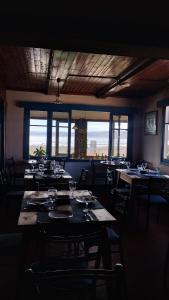 a dining room with tables and chairs and windows at Paldoa in Pichilemu +12 photos