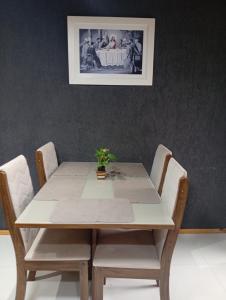 a dining room table with chairs and a picture on the wall at Casa completa em Bagé ideal para familias ate 6 pessoas WiFi e excelente localização in Bagé