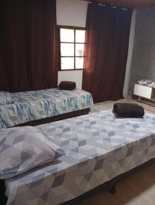 a bedroom with two beds and a window at Casa completa em Bagé ideal para familias ate 6 pessoas WiFi e excelente localização in Bagé