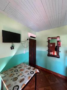 a room with a table and a tv on a wall at HOSTAL LUCERO in Humahuaca