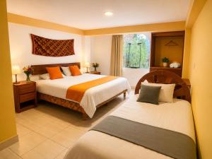 a bedroom with two beds and a window at Luz y Amistad - Pisac in Pisac
