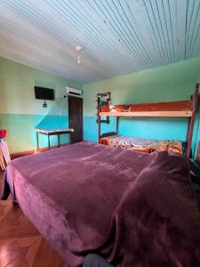 a bedroom with a bunk bed with a purple blanket at HOSTAL LUCERO in Humahuaca