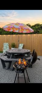 a patio table with an umbrella and a fire pit at The Stallion in Sturminster Newton
