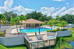 a pool at a resort with palm trees at Pet Friendly-Walk to PGA Resort in Palm Beach Gardens
