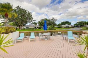 a patio with a table and chairs and a blue umbrella at Pet Friendly-Walk to PGA Resort in Palm Beach Gardens